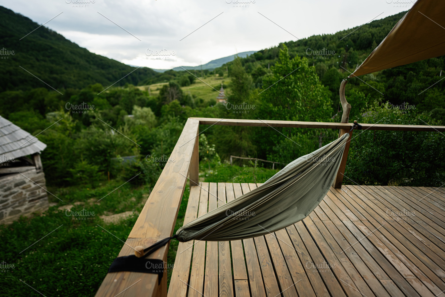 Wooden Deck with Hammock Overlooking Green Forest and Mountain Landscape, a Photo by AS photostudio