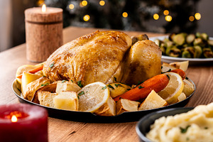 Whole roasted chicken with potatoes and vegetables.