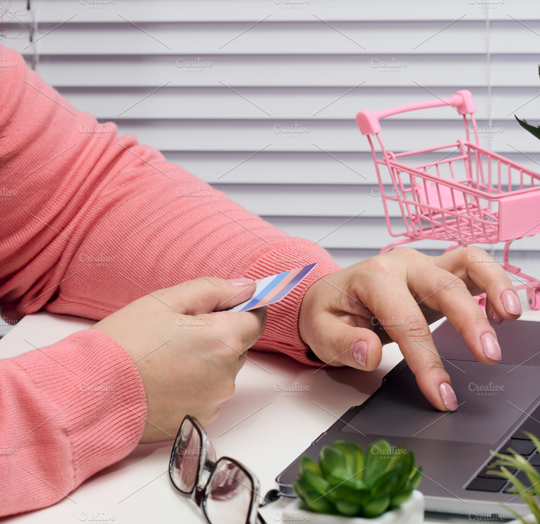 woman in a pink sweater makes purchases online with a laptop, a, a Business Photo by ndanko