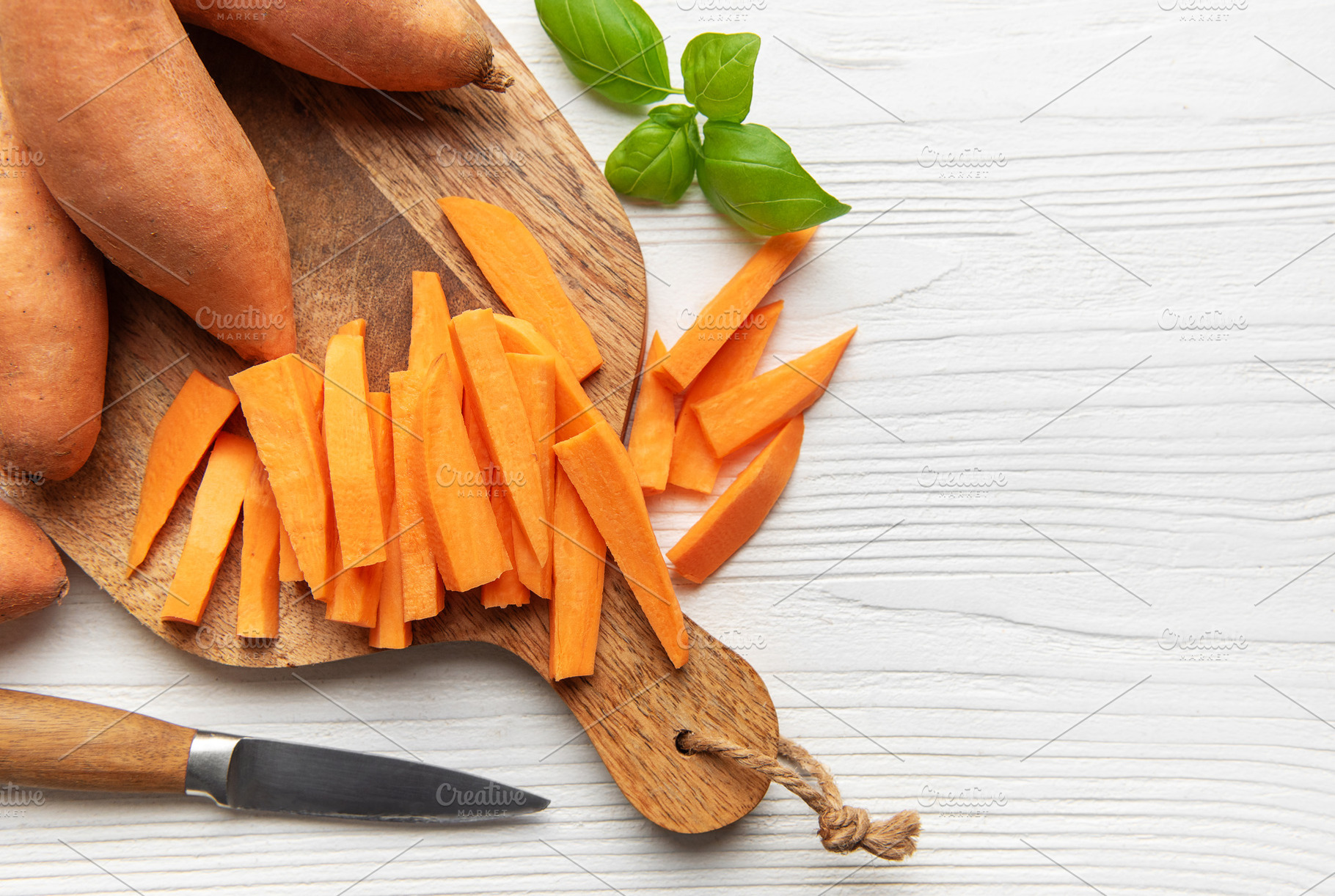 Preparing raw sweet potato fries on cutting board, a Food & Drink Photo by Olena Rudo