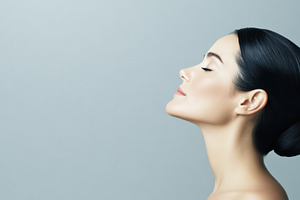 A stylish woman with sleek dark hair in a formal bun, glowing skin, and dramati, a Person Photo by Mashimara