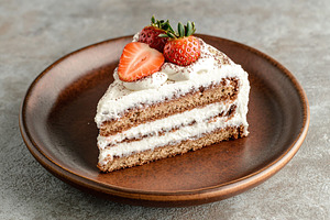 Delicious piece of cake with frosting cream, a Food & Drink Photo by AlyaAnd