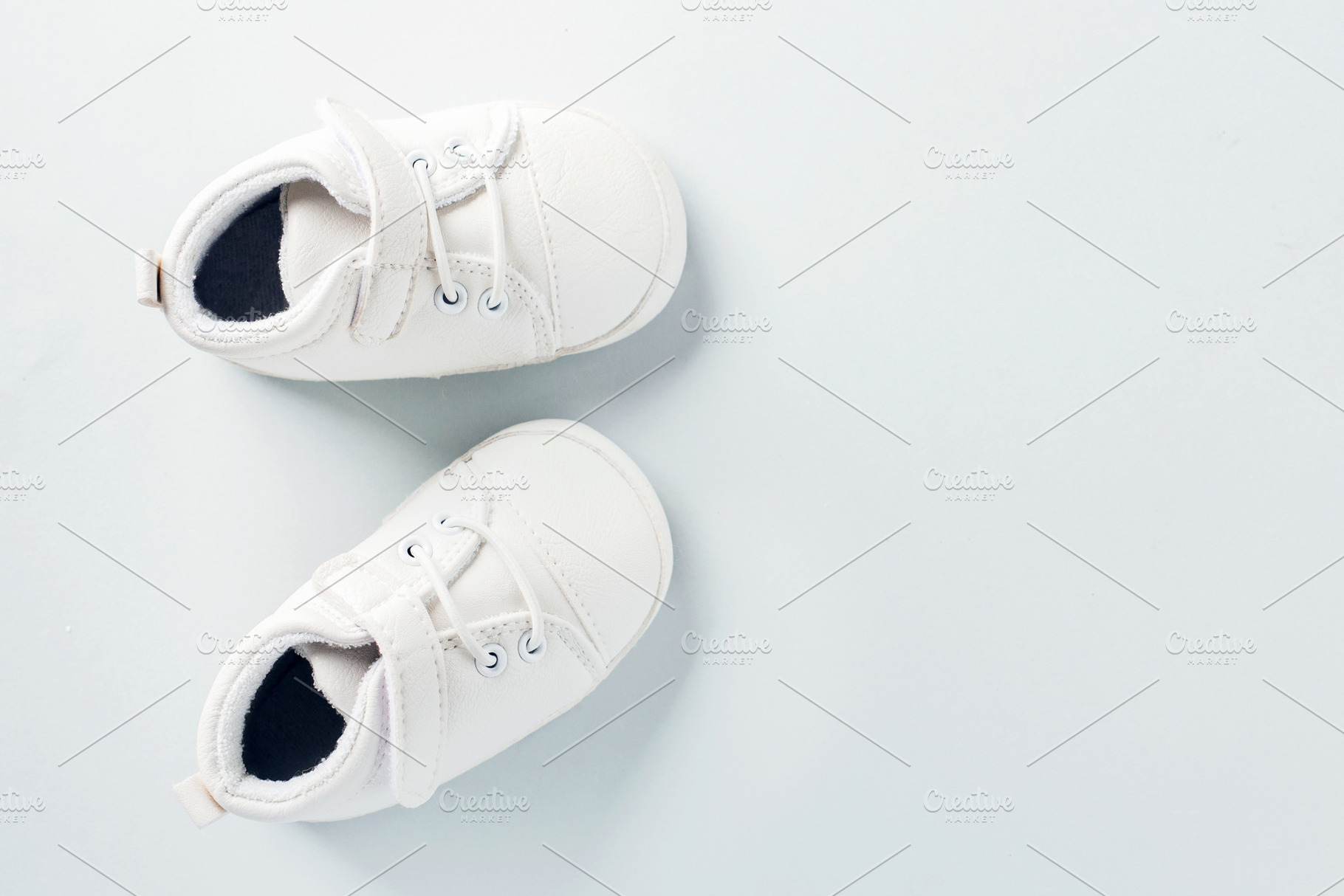 Tiny baby shoes on pastel background, an Abstract Photo by Valeria Art
