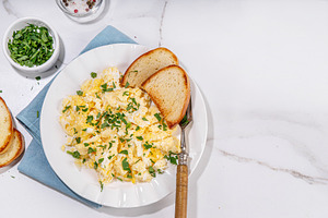 Traditional breakfast scrambled eggs with toasted bread, a Food & Drink Photo by Rimma