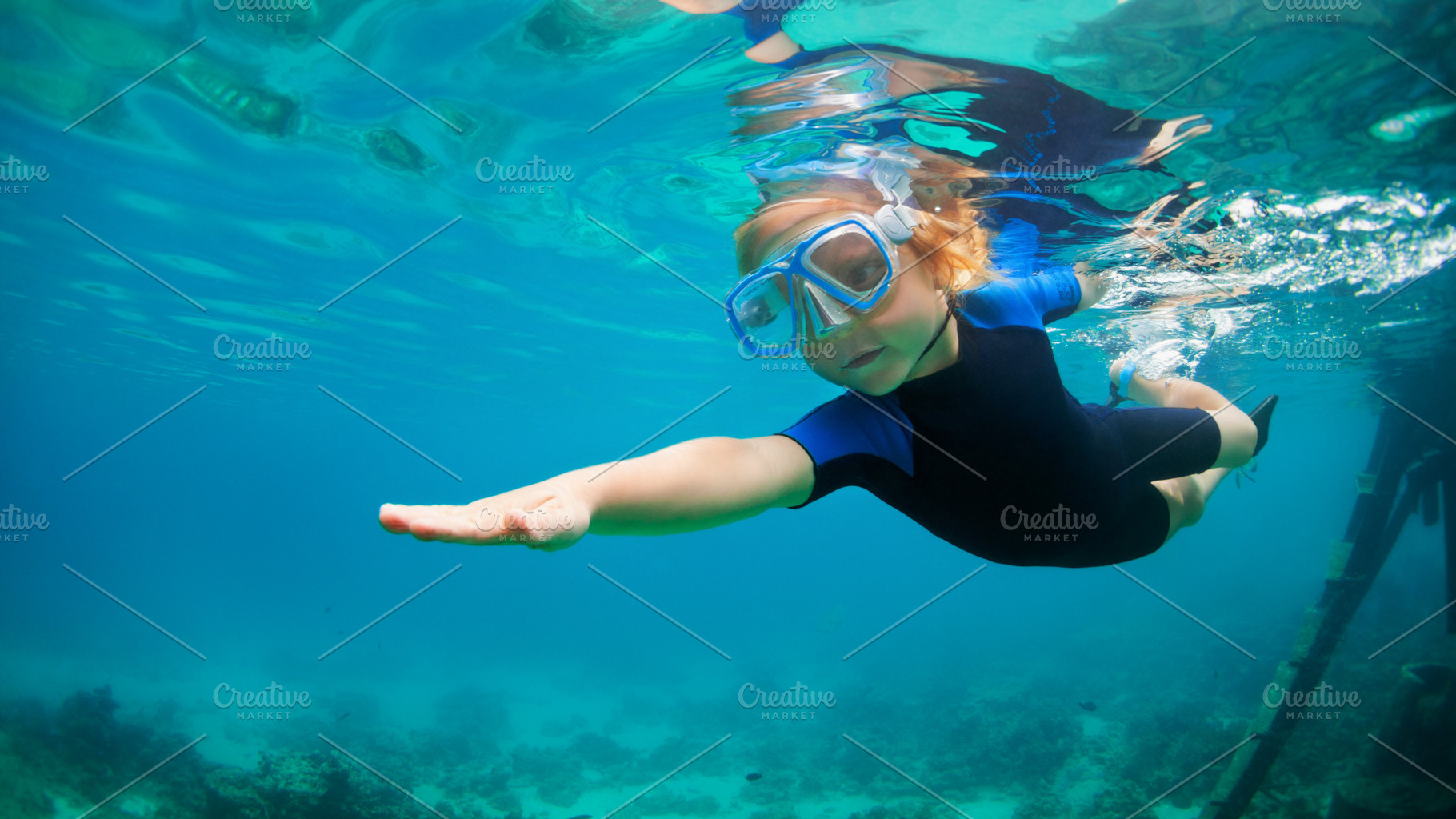 Child dive in snorkeling mask featuring family, holiday, and beach, a Person Photo by Tropical Studio