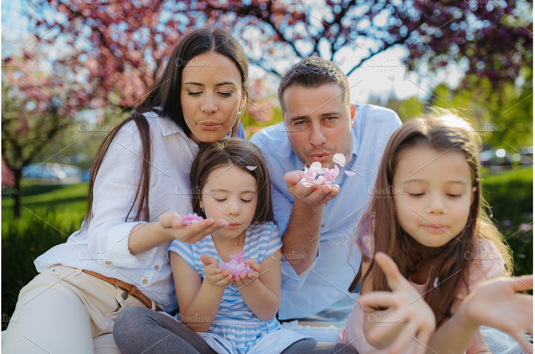 Family holding flower petals blowing, a Person Photo by HalfPoint