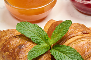 Fresh golden croissants on a wooden board with fruit jam and min, a Food & Drink Photo by ndanko