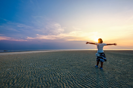 Woman standing arms outstretched at stock photo containing woman and beach, a Person Photo by yongkiet jitwattanatam