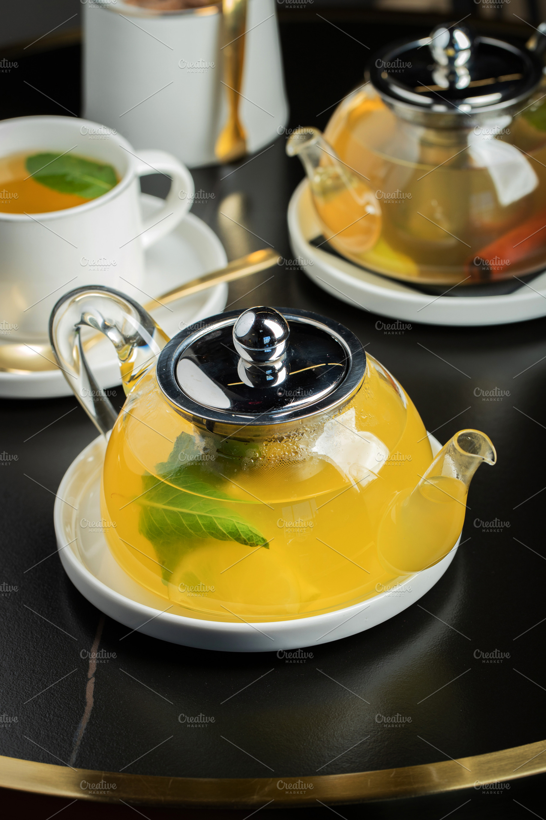Fruit tea with mango and mint in a glass teapot on the table, a Food & Drink Photo by Budarinphoto