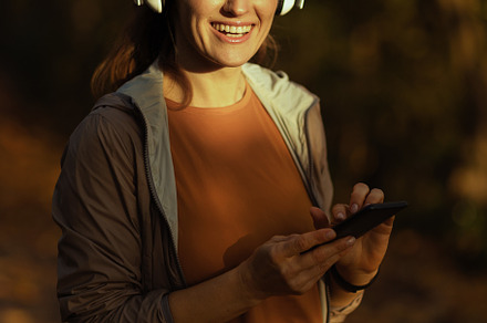 happy trendy woman in park listening to music with headphones, a Sports & Recreation Photo by Alliance Images