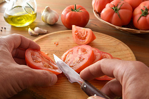 Hands Slicing Ripe Tomato on Wooden Board, a Food & Drink Photo by Davizro's Market