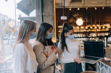 Three businesswomen with their face masks debating different views on work