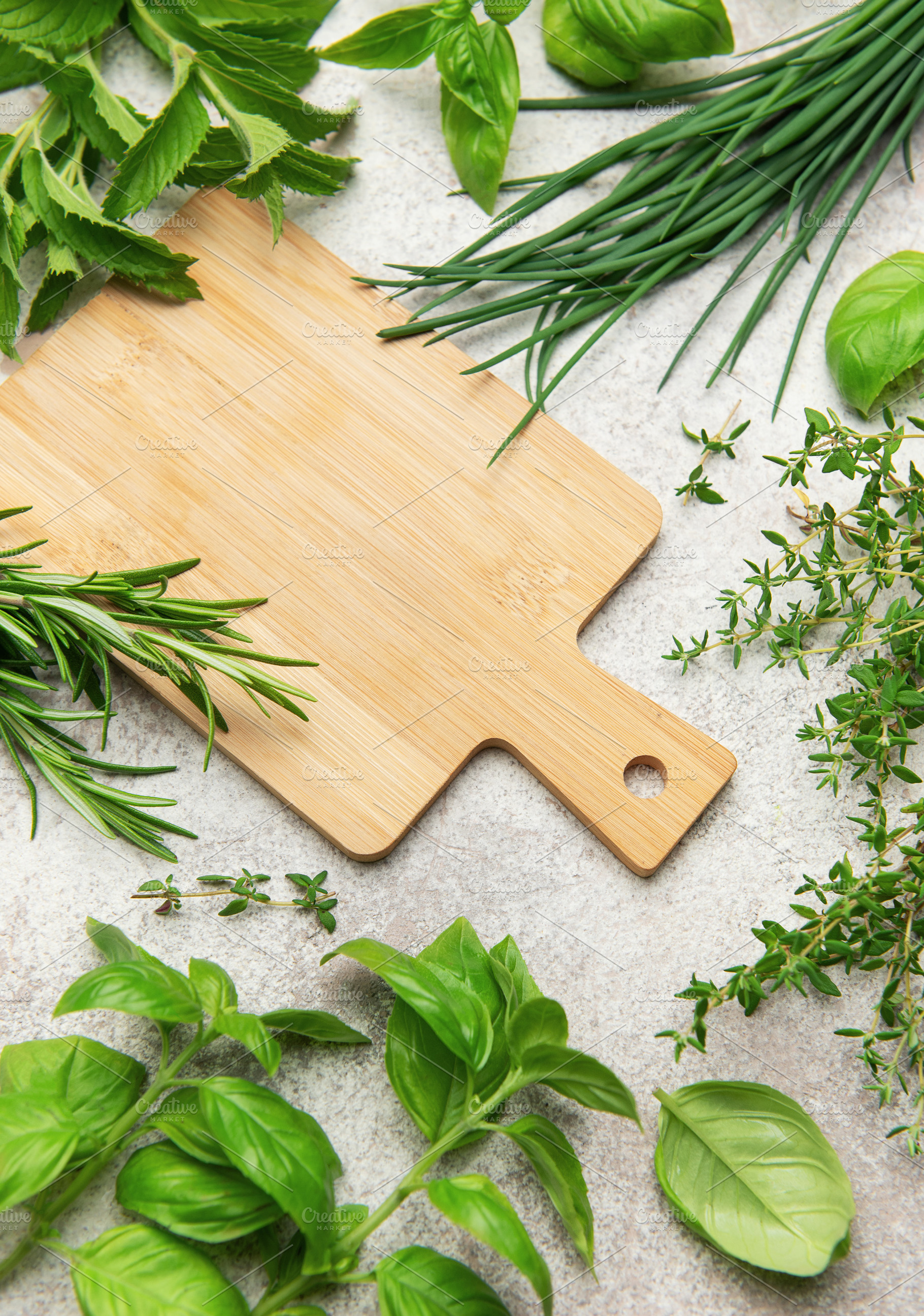 Fresh herbs and empty cutting board lying on kitchen table, a Food & Drink Photo by Olena Rudo