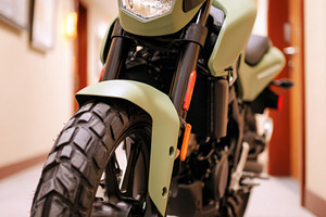 Green motorcycle in hotel hallway, a Transportation Photo by AlyaAnd