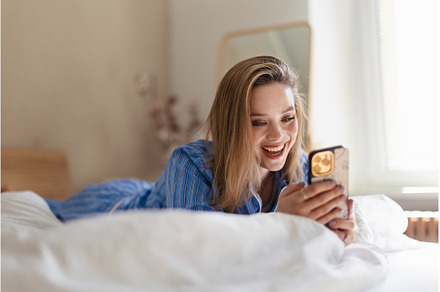 Young woman lying on a bed and, a Person Photo by HalfPoint