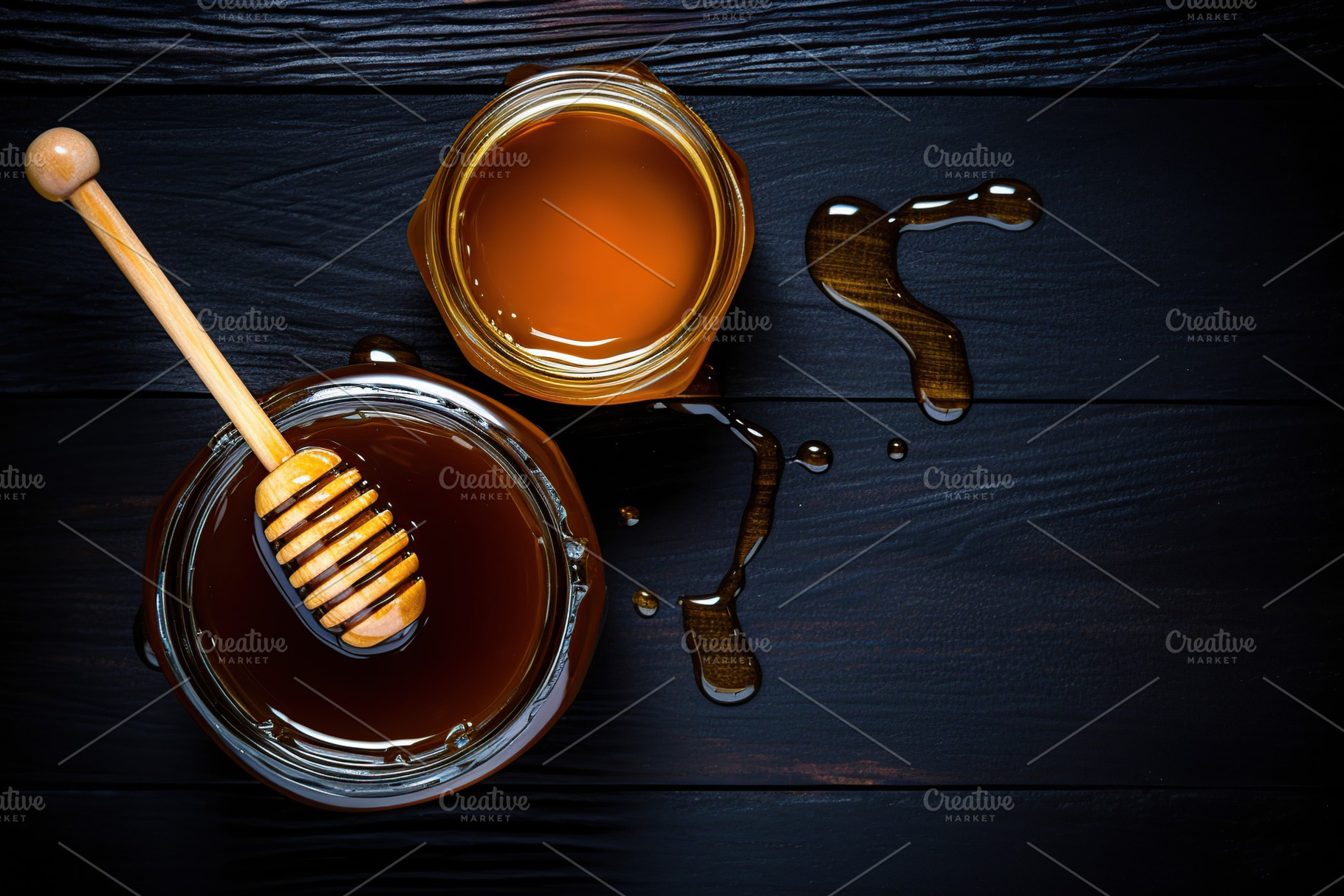 Honey in glass jar on wooden background, a Food & Drink Photo by AlyaAnd