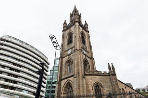 Historic Gothic church clock tower in Liverpool UK with stone fa