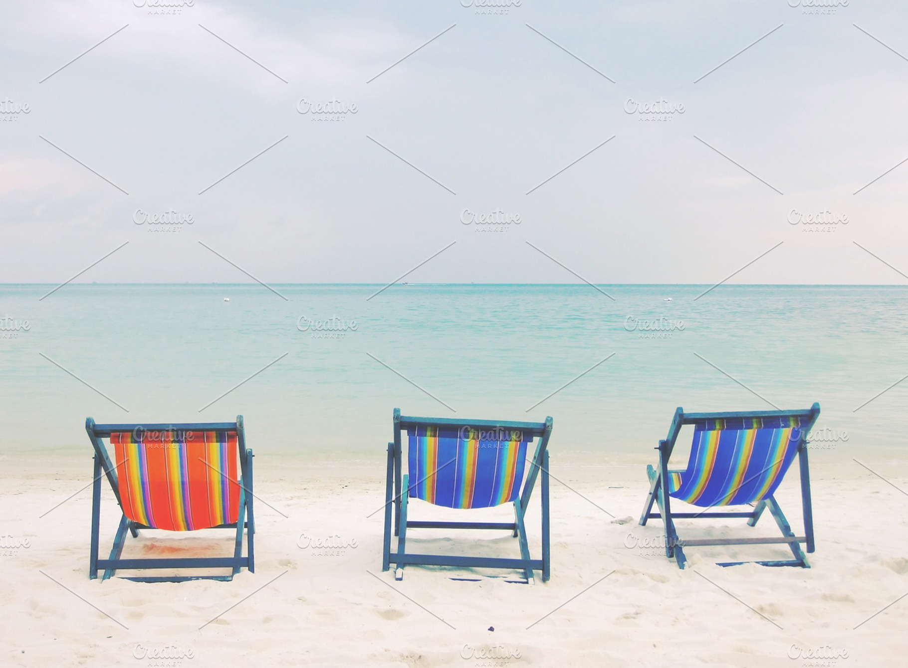 Three Deck Chairs On Beach