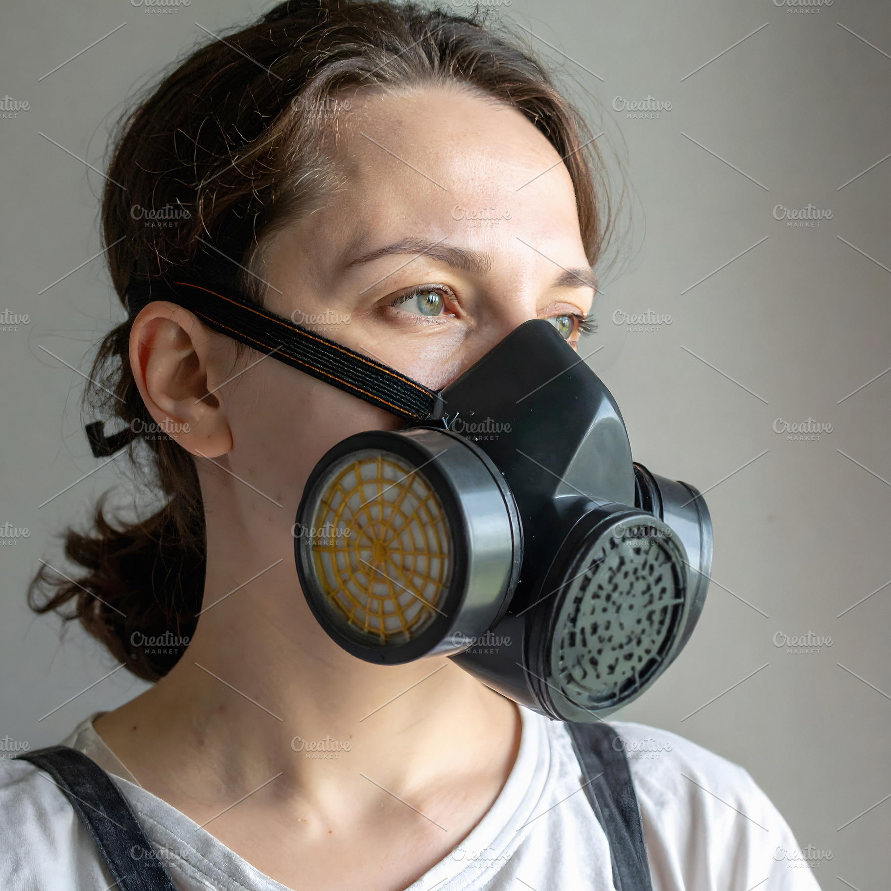 Woman wearing black gas mask looking away from window, a Person Photo by GoodGoods