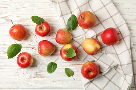 Composition with apples and towel on white wooden background, to, a Food & Drink Photo by AtlasStudio