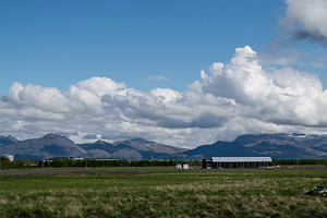 Mountain landscape with clouds and fields in Akranes, Iceland, a Photo by AS photostudio