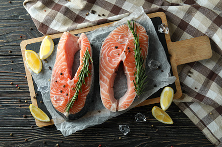 Concept of cooking salmon on wooden table, a Food & Drink Photo by AtlasStudio PRO