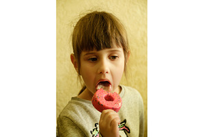 Little girl taking a bite of a pink, a Food & Drink Photo by Rohan Photography