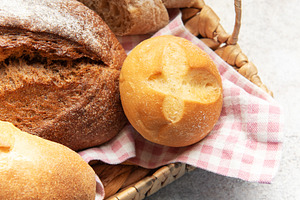 Assorted fresh crusty bread loaves in rustic basket, a Food & Drink Photo by Olena Rudo