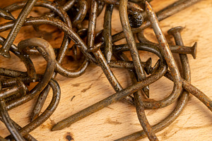 old broken and bent steel nails covered with rust, a Photo by rsoollAI