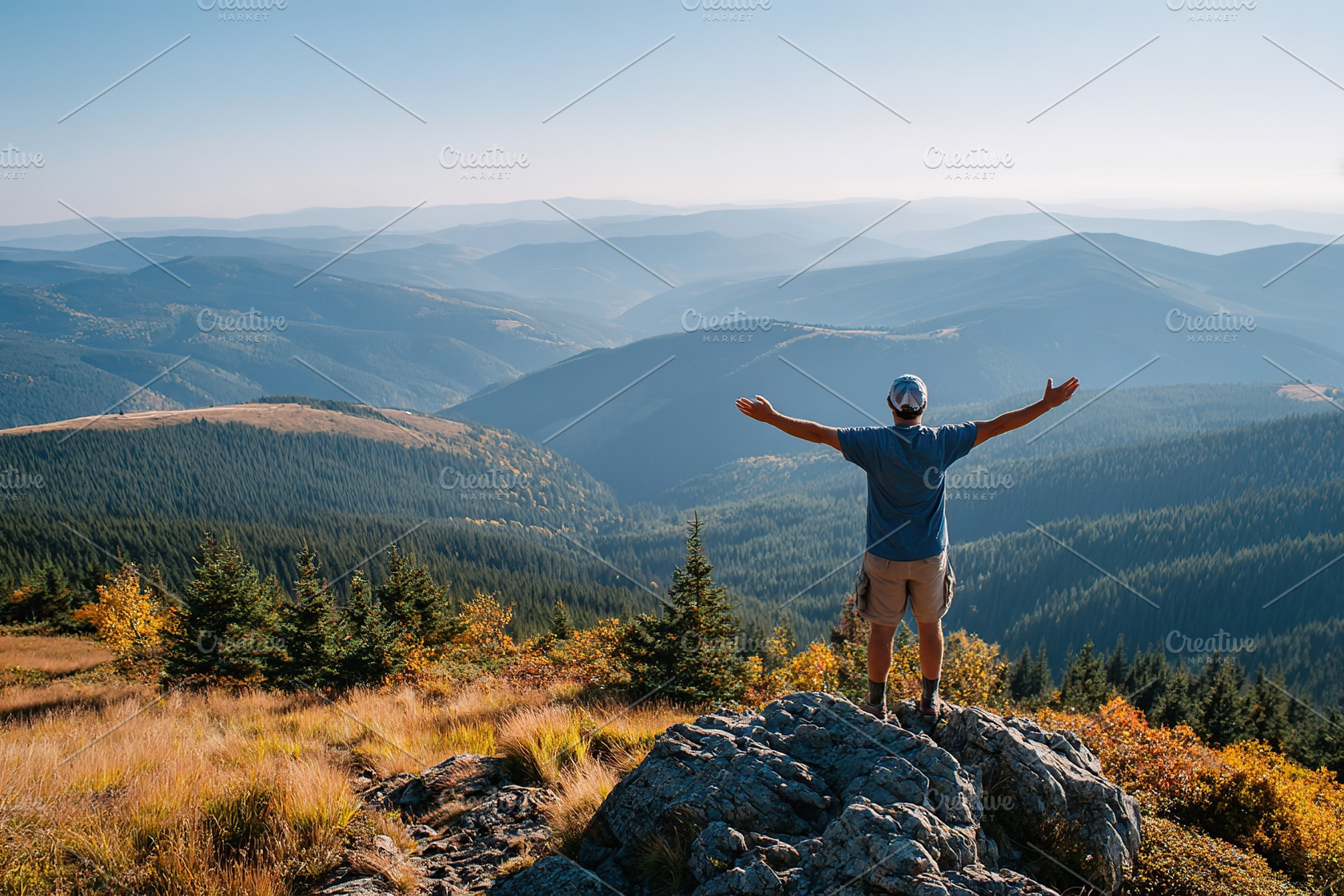 Standing on a mountaintop, a person enjoys fresh air and breathtaking views in, a Person Photo by AlyaAnd