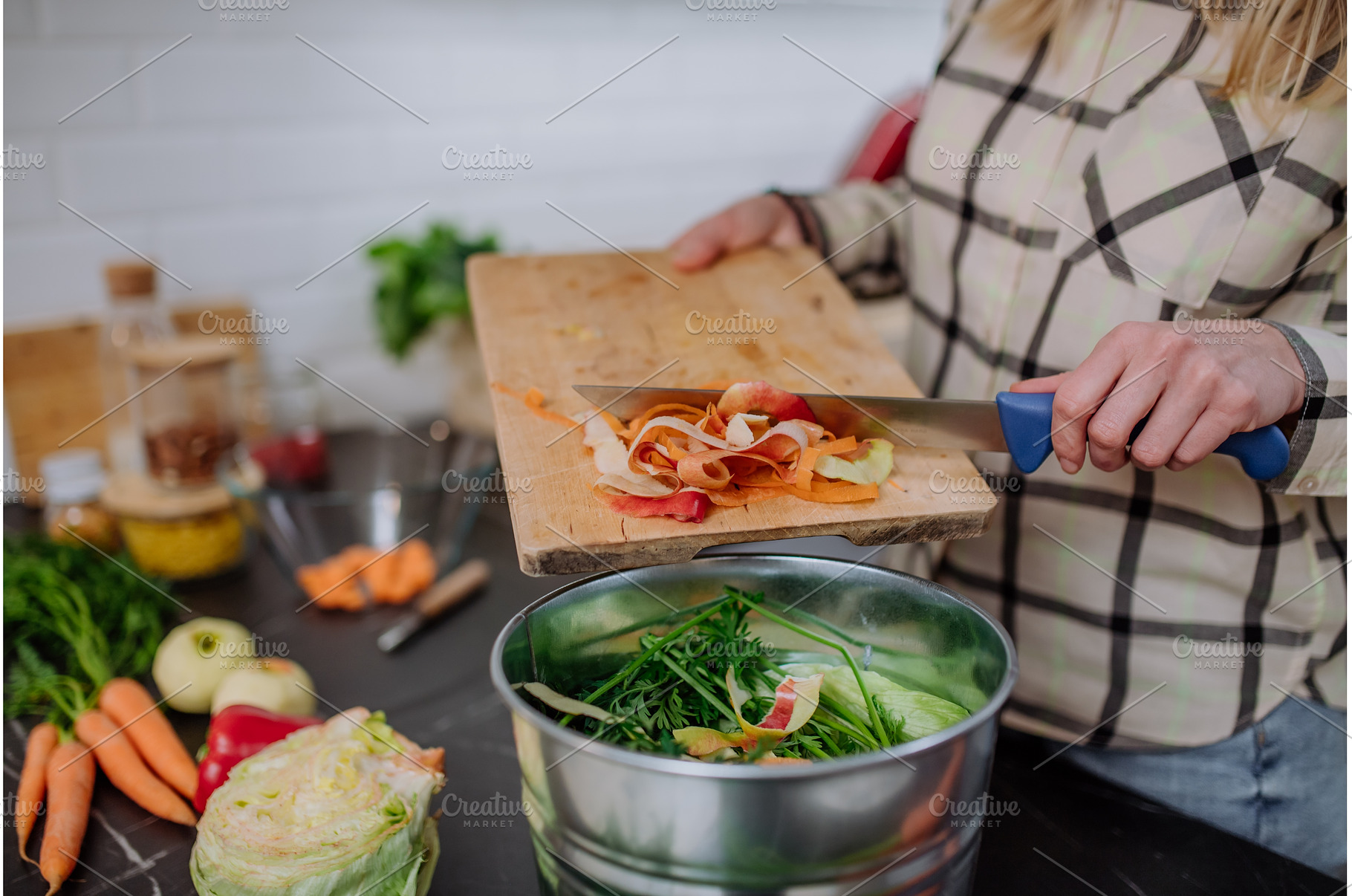 Woman throwing vegetable cuttings in, a Food & Drink Photo by HalfPoint