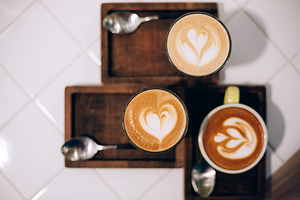 Three cups of latte art coffee on, a Food & Drink Photo by Anna Efetova