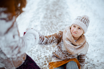 mother helping daughter getting up after falling, a Person Photo by Alliance Images