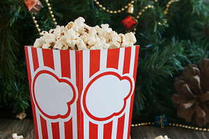Popcorn in the cup on background of christmas trees and decorations