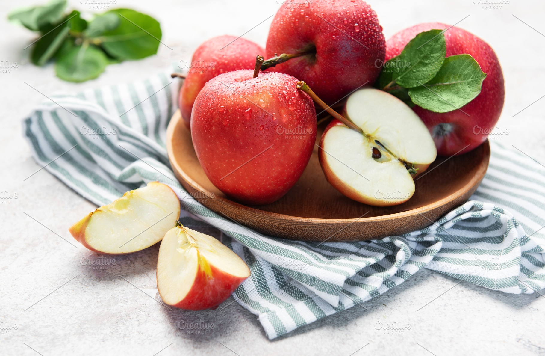 Fresh red apples in wooden bowl with slices, a Food & Drink Photo by Olena Rudo