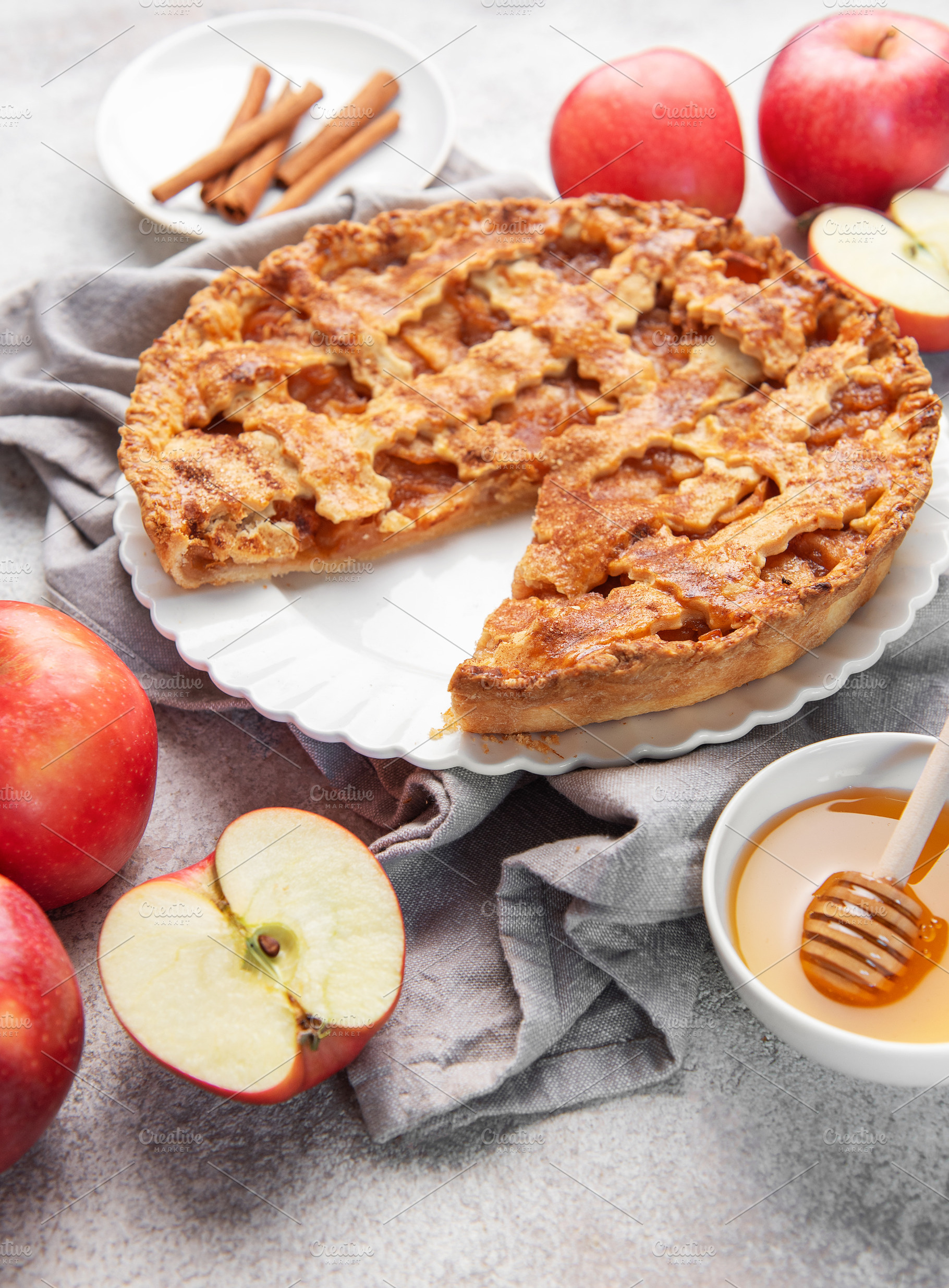 Apple pie with slice removed surrounded by fresh apples, a Food & Drink Photo by Olena Rudo