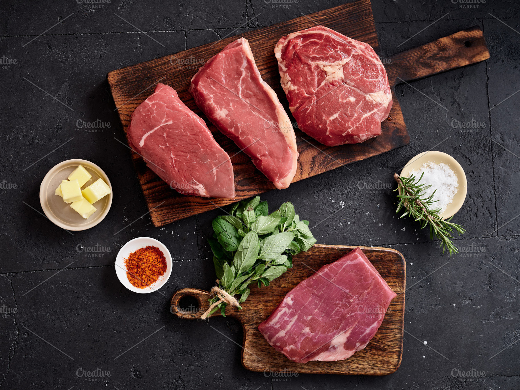 Raw rib-eye, roast beef, flank and rump steak on wooden cutting boards with her, a Food & Drink Photo by Asya Nurullina