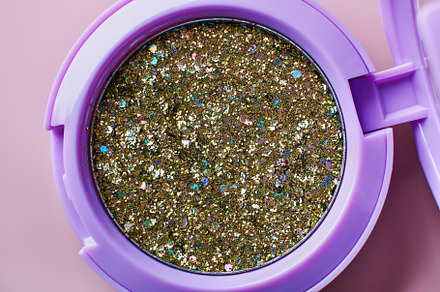 Golden sequins for face and body in a container close-up, a Beauty & Fashion Photo by colnihko