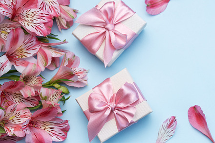 Beautiful Alstroemeria flowers and gift boxes on blue background, a Holiday Photo by Olena Rudo