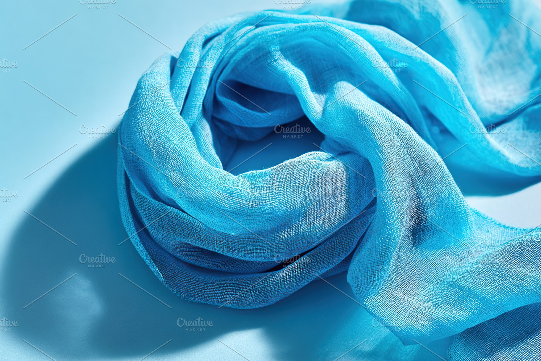 Elegant blue scarf on light background, an Abstract Photo by AlyaAnd