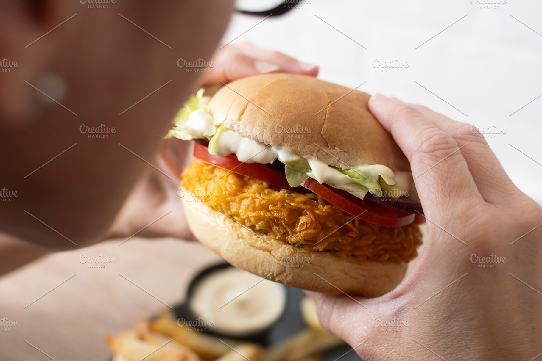 Woman holding crispy chicken burger, a Food & Drink Photo by etorres69