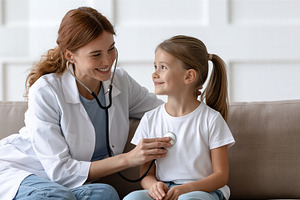 Doctor examining young girl, a Health & Medical Photo by 7DesignLab
