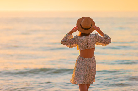 Young beautiful woman at straw hat on the beach at sunset, a Person Photo by travnikovstudio