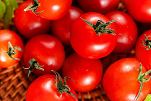 Cherry tomatoes resting in rustic wicker basket, a Food & Drink Photo by Olena Rudo