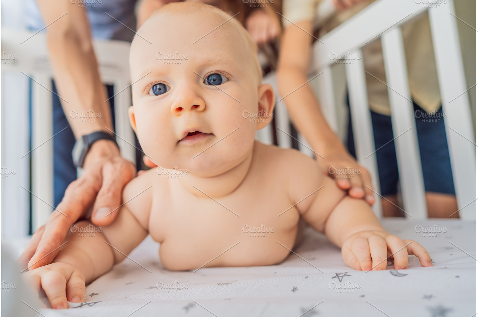 Baby lying on stomach in crib with, a Person Photo by Elizaveta Galitskaya