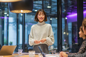 Young woman presenting to colleagues, a Photo by Pixeness Studio
