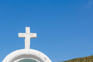 White cross standing on a roof under blue sky, a Photo by Antonio Gravante Market