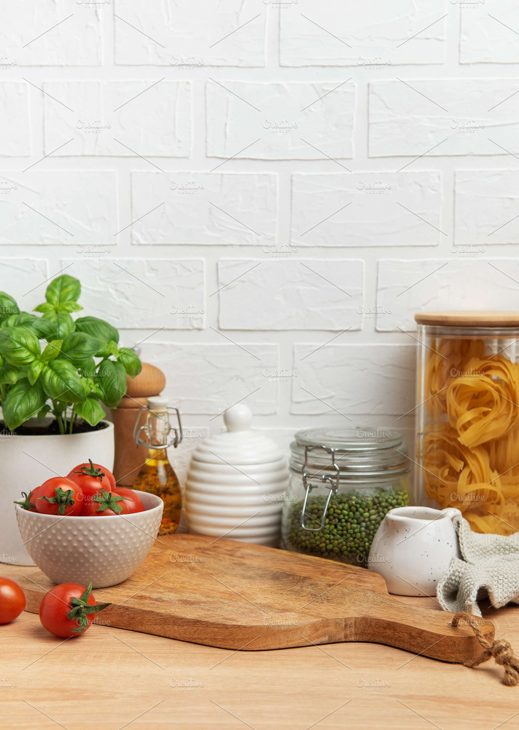 Empty wooden cutting board with various ingredients and utensils, a Food & Drink Photo by Olena Rudo