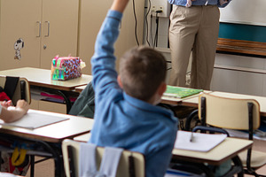 Elementary School Student Raising Hand During Classroom Lesson with Teacher, a School & Education Photo by etorres69
