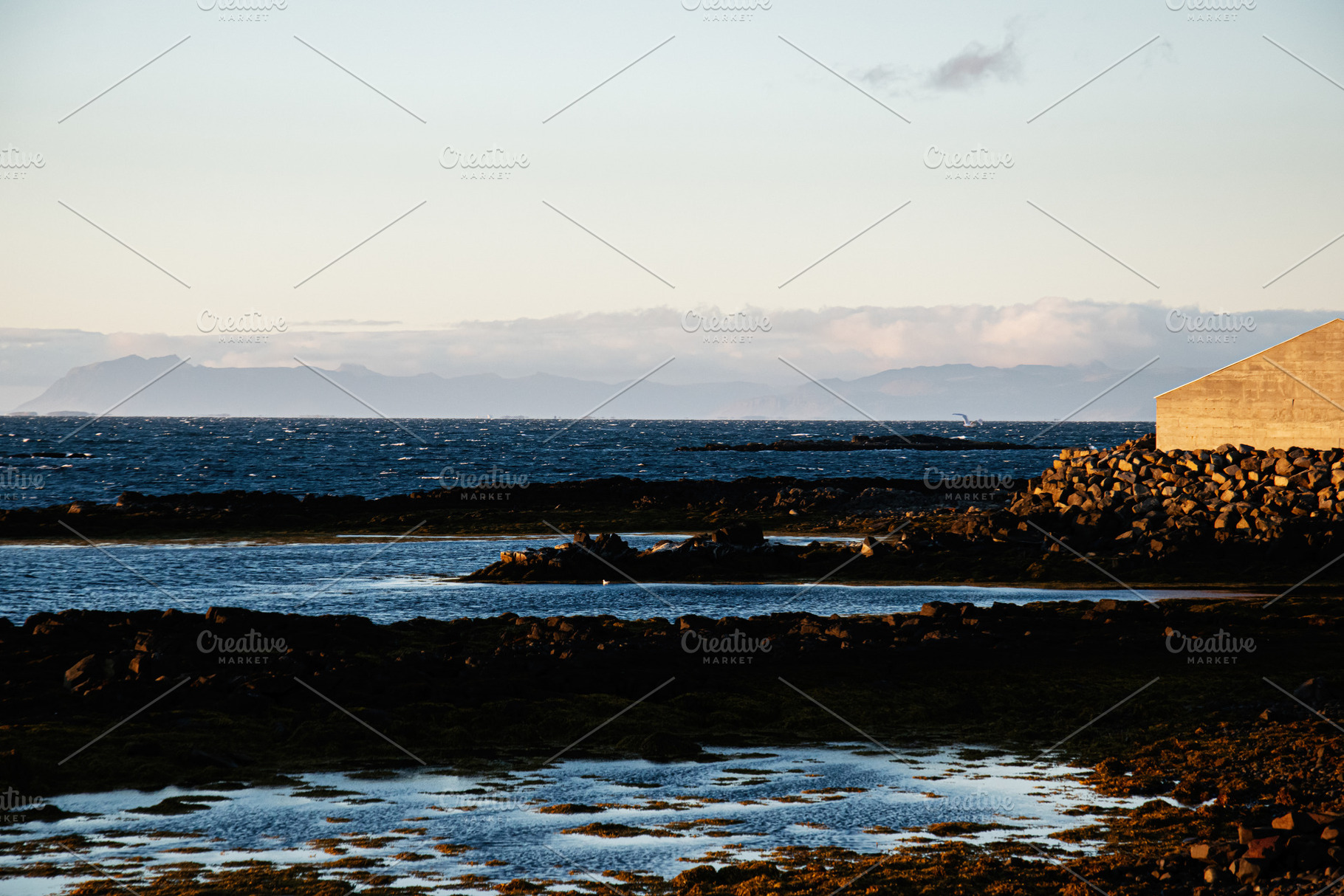 Serene coastal landscape view of Iceland with distant mountains and tranquil wa, a Nature Photo by AS photostudio